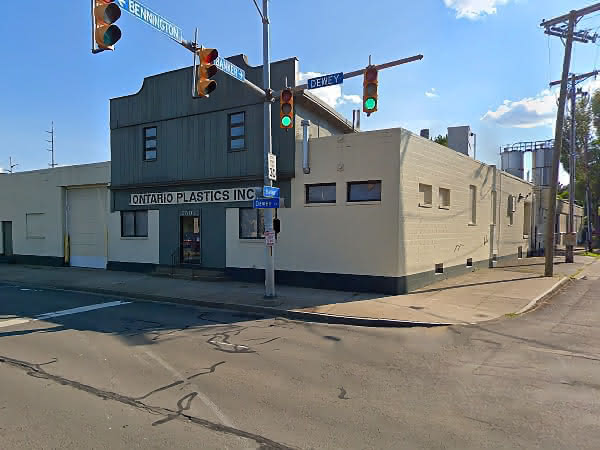 An industrial building with a small shop front viewed from a street corner.